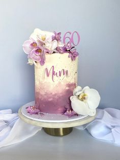 a pink and white cake sitting on top of a table next to a flower covered plate