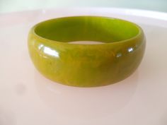 This 1930s vintage bangle in a bit of a weird and wonderful green pairs beautifully with Bakelite in orange and butterscotch . . . you'll see for yourself in the last photograph :) * Yes, it is Bakelite. * Bangle dating to the 1930s. * Green with a bit of a yellow swirl running through it. * Measures 2.5 inches in diameter, on the inside . . . meaning it fits someone with small hands. * On the inside, measures approximately 5/8 of an inch wide. * As you will see in the last photograph orange Bak Bakelite Bangles, Gunne Sax, Velvet Flowers, Vintage Bangles, Vintage Velvet, Small Hands, Weird And Wonderful, Stainless Steel Bracelet, Swirl