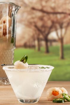 a glass filled with ice and garnish sitting on top of a wooden table