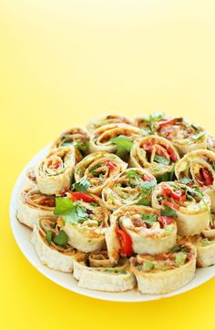 a plate filled with rolls and vegetables on top of a yellow table