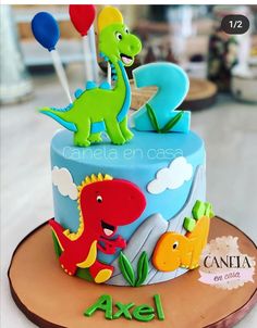 a birthday cake decorated with an image of a dinosaur on top and balloons in the background