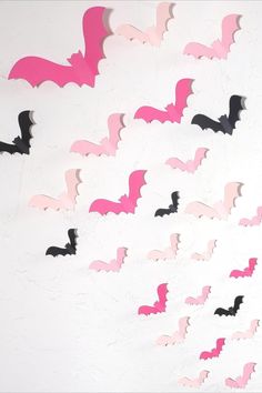 a group of pink and black bats on a white wall