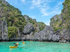 several people are kayaking in the clear blue water