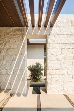 an entry way to a house with a tree in the center and water running through it