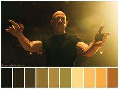 a man is holding his hands out in front of the camera, with color swatches