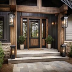 the front door of a house with two lights on it and potted plants outside