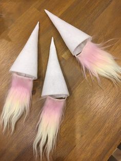 three white cones with pink and yellow feathers