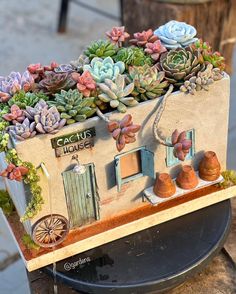 a house made out of clay with succulents in it