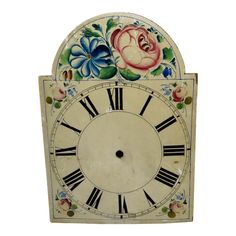 an old clock with flowers painted on it