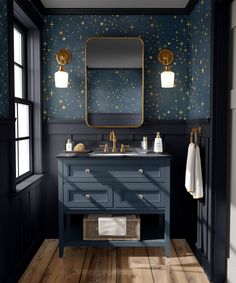 a bathroom with blue vanity and gold stars on the wall