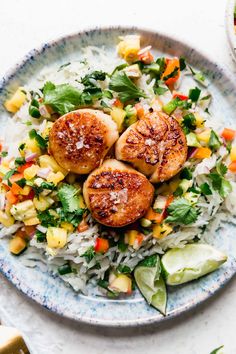 scallops on top of rice in a blue and white bowl next to other food