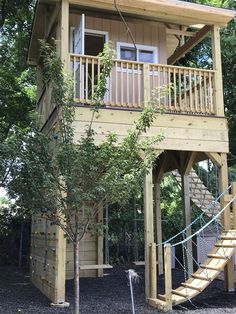 a tree house with stairs leading up to the top floor and second story above it