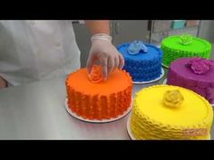 a chef is decorating several cakes with colorful icing