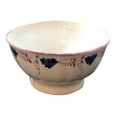 a white bowl with blue and red designs on the rim is sitting in front of a white background