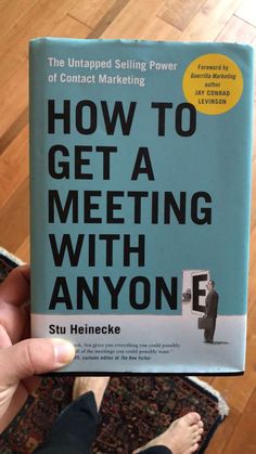 the book how to get a meeting with anyone is being held up in front of a person's feet