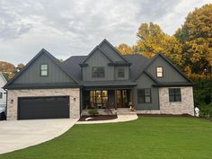 a gray house with two garages in the front yard