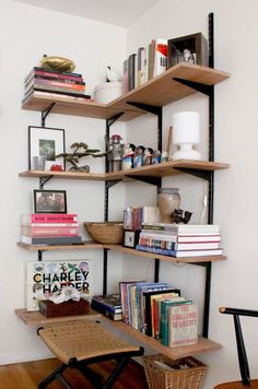 a bookshelf filled with lots of books next to a wooden chair and table