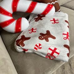 two christmas themed items are sitting on the couch next to each other, one with a candy cane