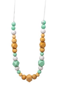 a wooden beaded necklace with green and white beads