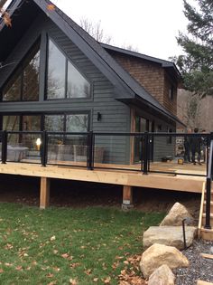 a large house with a deck and glass windows