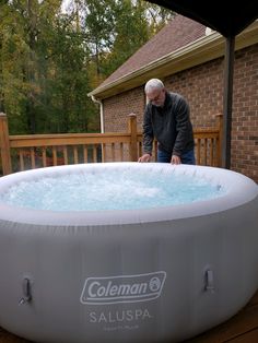 an older man standing next to a large inflatable hot tub