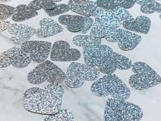 silver glitter heart confettis on a marble table