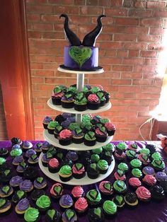 three tiered cupcake display with green and purple frosting on it's sides