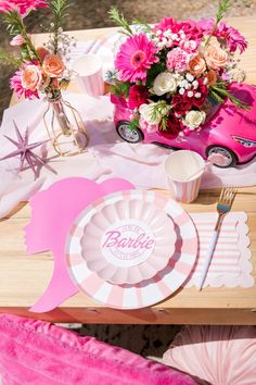 a table topped with pink flowers and plates