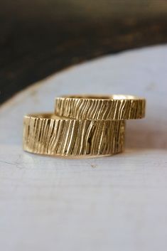 two gold rings sitting on top of each other