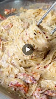 a bowl filled with pasta and meat being stirred