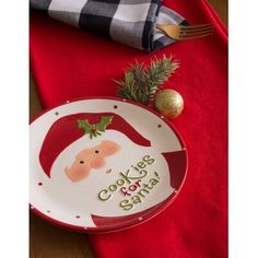 a plate with a santa clause on it sitting on a table next to a napkin