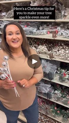 a woman is standing in front of christmas ornaments and holding a bouquet with the caption here's a christmas tip for you to make your tree sparkle even more