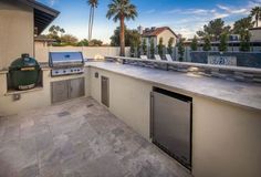 an outdoor kitchen with stainless steel appliances and grill