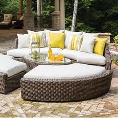 an outdoor patio furniture set with yellow and white pillows