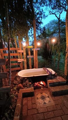 a bathtub sitting in the middle of a brick patio next to a fire pit