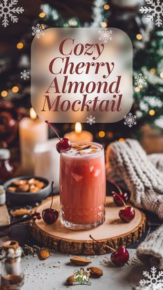 a drink with ice and cherries sitting on top of a wooden table next to a christmas tree