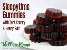 a white plate topped with lots of jelly gummys next to a pile of honey