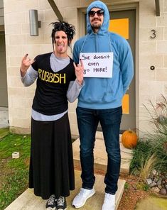 two people dressed up in costumes standing on the steps with one holding a sign that says rubbish