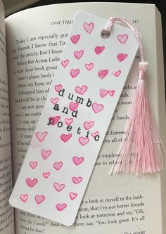 the bookmark is decorated with pink hearts and tassels on it's side