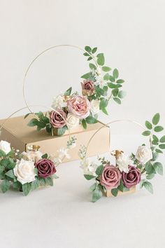 three flower arrangements sitting on top of a box