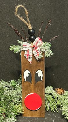 a christmas decoration made out of wood with reindeer's nose and nose painted on it