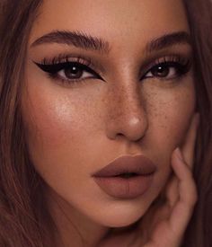 a woman with freckles on her face and brown hair is posing for the camera