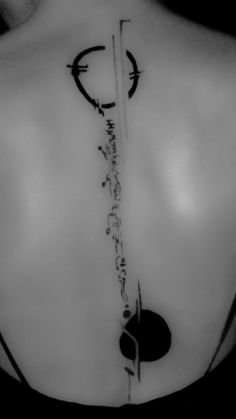 the back of a woman's shoulder with an arrow and circle tattoo on it