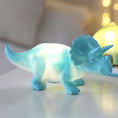 a plastic dinosaur toy sitting on top of a table