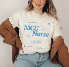 a woman wearing a white shirt with the words nicu nurse on it, sitting down