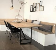 a long table with chairs and a vase on it in the middle of a room