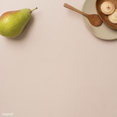 two pears and banana slices are on a plate next to a bowl of bananas