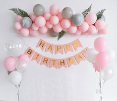 a birthday party with balloons, streamers and garlands in pastel pink, grey and white colors