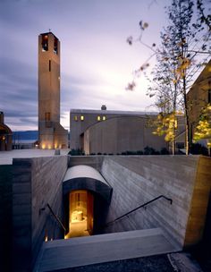 a building with a clock tower in the middle of it's entrance way at night