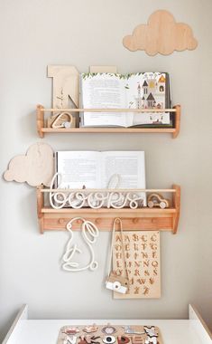 two wooden shelves with books and other items hanging on the wall next to each other